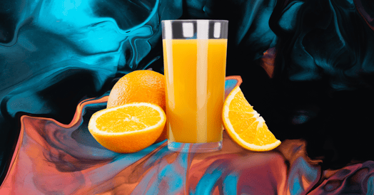 A glass of orange juice and three oranges against a blue and peach background.